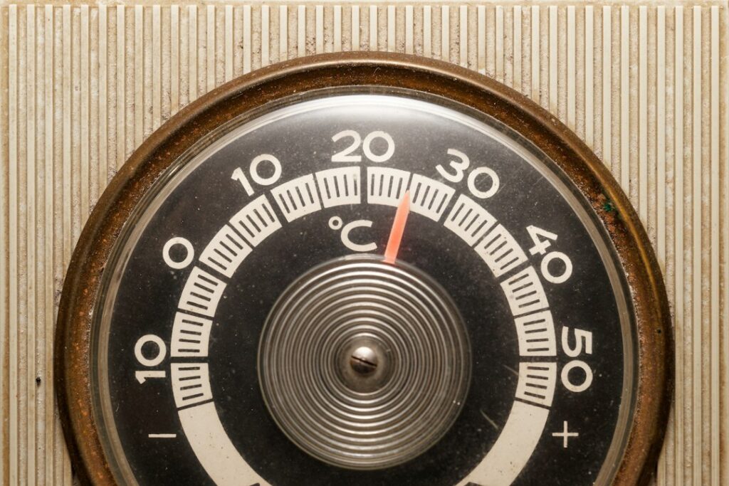 Close-up of a vintage thermostat displaying temperature settings.