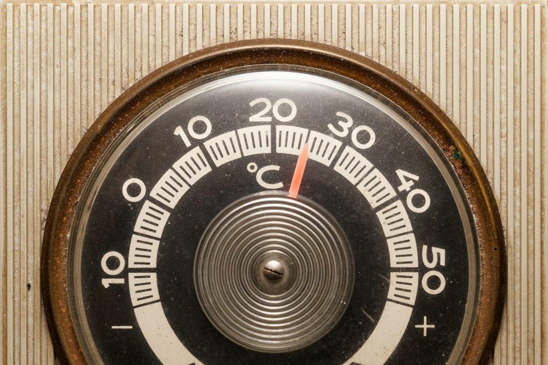 Close-up of a vintage thermostat displaying temperature settings.